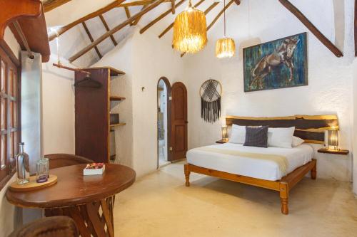 a bedroom with a bed and a table in it at Zomay Beachfront Holbox in Holbox Island