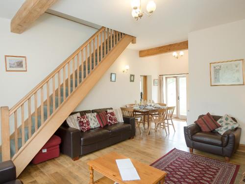 a living room with a staircase and a table at The Stable in Foxham