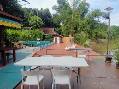a patio with tables and chairs next to a pool at Tonnam Homestay in Chiang Mai