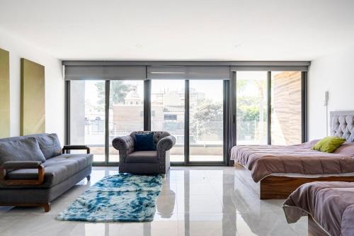 a bedroom with a bed and a couch and a chair at Casa para 16 personas con alberca climatizada in Guadalajara