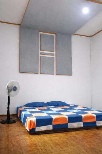 a bedroom with a bed in a room with a fan at NATA homestay in Banggai