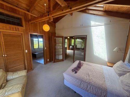 a bedroom with a bed and a couch in a room at Abel Tasman guest house in Marahau
