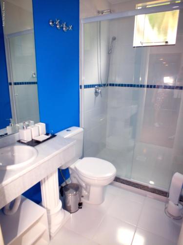 a bathroom with a toilet and a glass shower at The Hyperion Boutique Hotel in Florianópolis