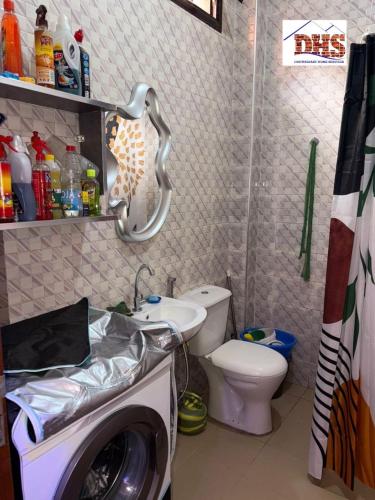 łazienka z pralką i toaletą w obiekcie DHS Home w mieście Pikine