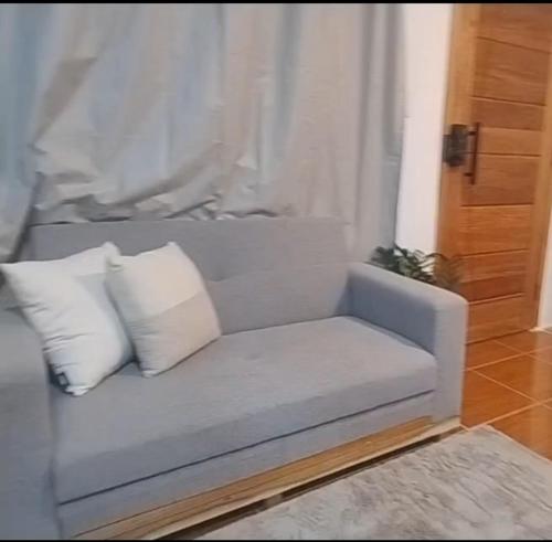a couch with two pillows sitting in a living room at Lofts Baronesa in São José dos Campos