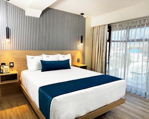 a bedroom with a large bed and a large window at Rest Inn Baja in Ensenada