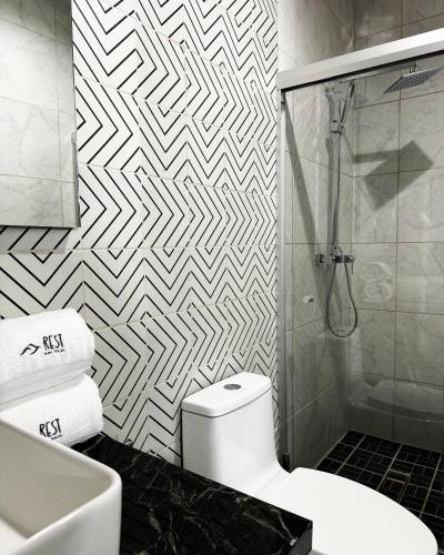 a bathroom with a white toilet and a shower at Rest Inn Baja in Ensenada