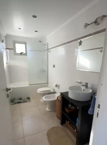 a white bathroom with a toilet and a sink at CoSTA Y MAR II in Villa Gesell