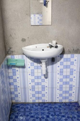 a white sink in a bathroom with blue tiles at NATA homestay in Banggai