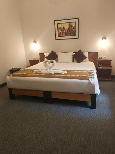 a bedroom with a large bed with a bow on it at Colonial Plaza Hotel in Puno