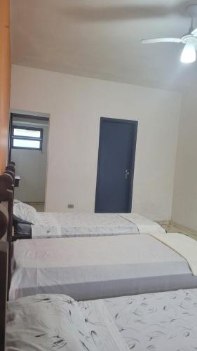 a room with three beds and a window at Pousada hotel da ilha lounge Beach Lucas do Gelo in Ilha Comprida