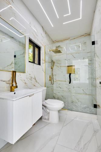 a bathroom with a toilet and a glass shower at Sunset Havendale in Kingston