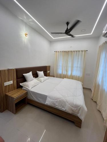 a bedroom with a bed and a ceiling fan at MR Homes in Cochin