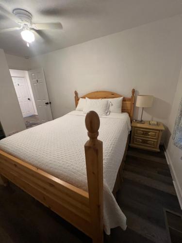 a bedroom with a wooden bed with a white bedspread at Near Red Mountain park in Mesa