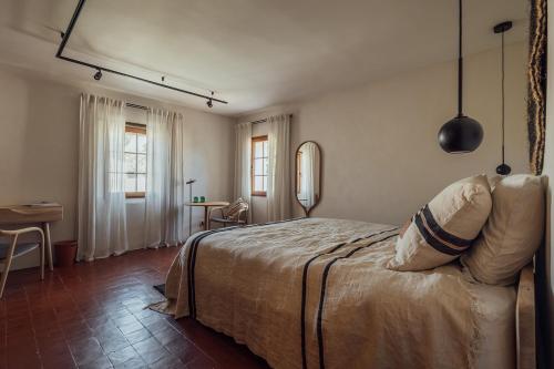 sypialnia z łóżkiem, stołem i oknem w obiekcie Le Pavadou B&B w mieście Méthamis