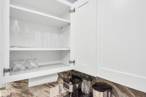 a white kitchen with white cabinets and a blender at 2 BR Cottage Midtown Downtown EADO in Houston