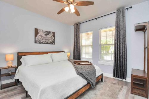 a bedroom with a bed and a ceiling fan at 2 BR Cottage Midtown Downtown EADO in Houston