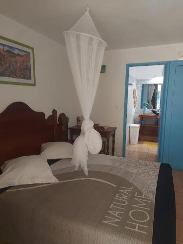 a teddy bear standing on the end of a bed at Studios Soleil du Sud in Sainte-Anne
