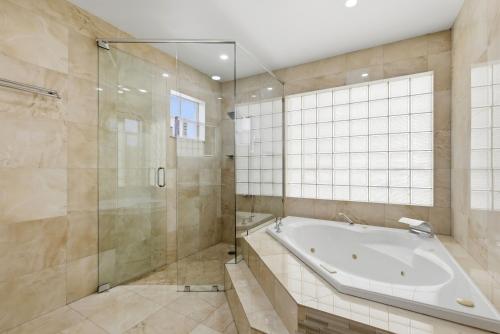 a bathroom with a tub and a glass shower at Miami Retreat, Private Pool and Patio 3B in Miami