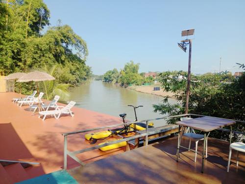 a boat with a kayak on a dock next to a river at Tonnam Homestay in Chiang Mai