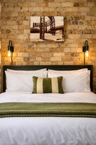 a bedroom with a white bed with a brick wall at Balmain Village Retreat AC Free Street Parking City 3km in Sydney