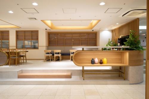 a lobby of a hotel with a table and chairs at Hotel Hokke Club Fukuoka in Fukuoka