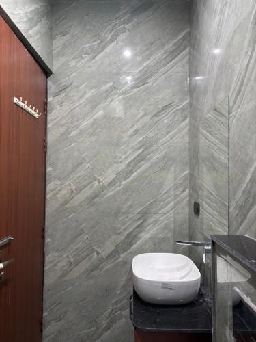 a bathroom with a toilet and a stone wall at Kamlkash niwas homestay in Rishīkesh