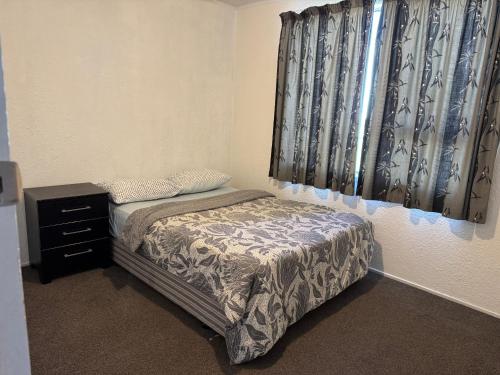 a small bedroom with a bed and a dresser at Private Rooms at Bayfair in Tauranga