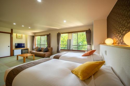 a bedroom with two beds and a living room at KKRzaoHakuginso in Yamagata