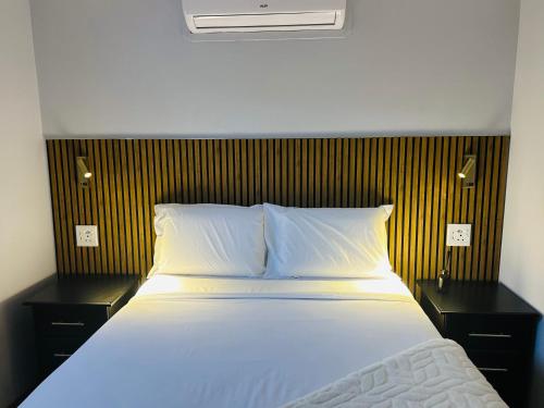 a bedroom with a bed with two nightstands and a white bedspread at Siyaya Palace in Jozini