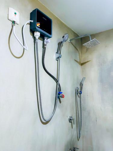a shower in a bathroom with a soap dispenser at Sigiriya Carpenter Cottage in Sigiriya