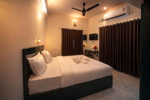 a bedroom with a bed with white sheets and pillows at Skytouch Residency-OMR in Chennai