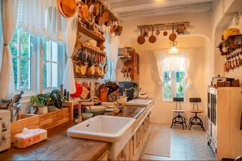 a kitchen with two sinks and a counter with windows at Home Tower tree เชียงใหม่ in Pong Yaeng