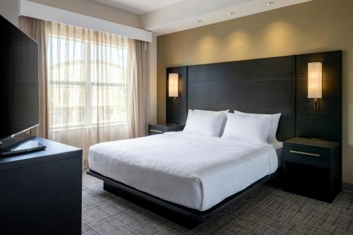 a bedroom with a large bed and a large window at Residence Inn Melbourne in Melbourne