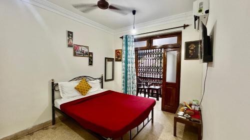 a bedroom with a bed with a red blanket at Muffys Baga Apartment in Baga