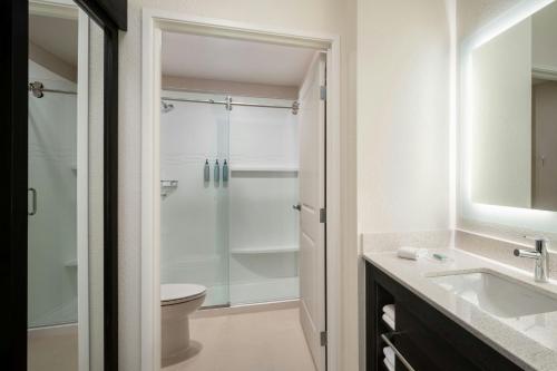 a bathroom with a shower and a sink and a toilet at Residence Inn Melbourne in Melbourne