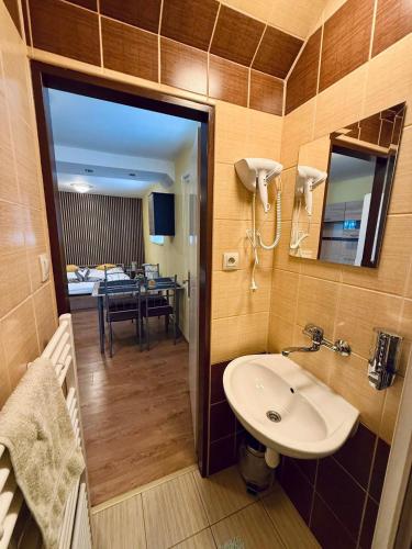 a bathroom with a sink and a room with a table at Privat Horec in Malý Slavkov