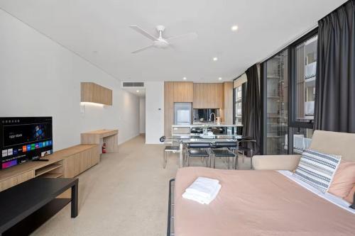 a living room with a couch and a dining room at Level 10 Views 2BR with Private Balcony & Parking in Brisbane