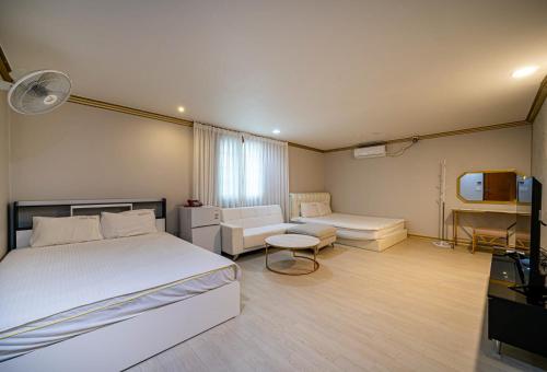 a bedroom with a bed and a couch and a tv at 센스모텔 in Sasang-yŏk