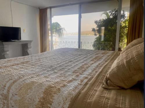a bedroom with a bed with a view of the ocean at Hotel Marina Palace Tequesquitengo in Tequesquitengo