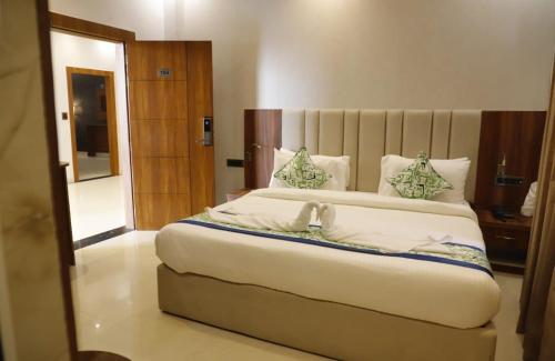 a bedroom with a large white bed with a mirror at AmarVandana Palace in Rādha Kund