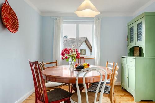 a dining room table with a vase of flowers on it at Zita Ferienhäuser - Ferienhaus Burgi in Neckargemünd