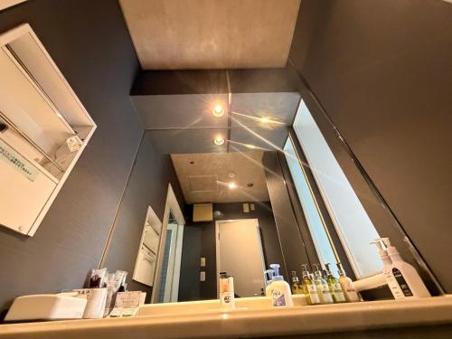 a bathroom with a large mirror over a sink at ホテルメイプル in Odate