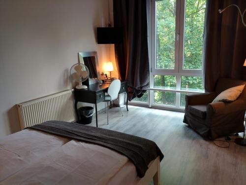 1 dormitorio con cama, escritorio y ventana en Midi Inn Parkhotel Mitte, en Berlín