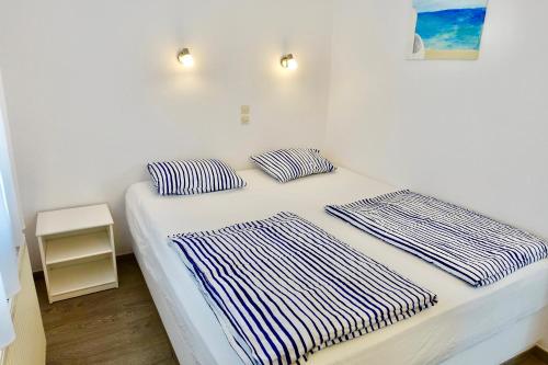a bed with two pillows on it in a room at Villa Kamari in Kastraki