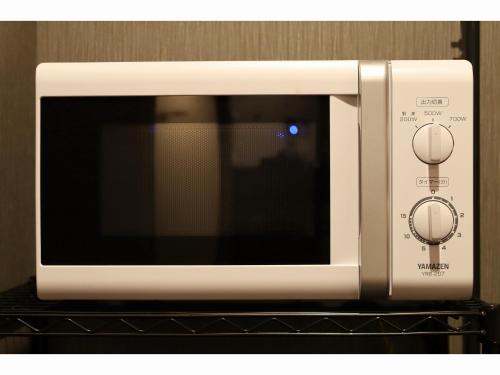 a white microwave oven sitting on top of a shelf at Smile Hotel Aomori in Aomori