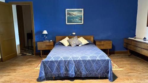 a blue bedroom with a bed with a blue wall at La Guevarina- Casa de Campo in Tres Esquinas