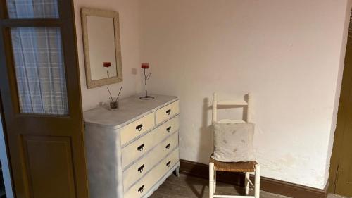 a bedroom with a dresser and a mirror and a chair at La Guevarina- Casa de Campo in Tres Esquinas