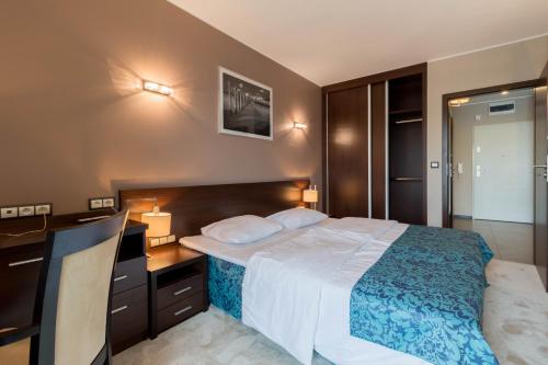 Pokój hotelowy z łóżkiem i biurkiem w obiekcie Apartamenty Aquarius z Aquacenter w Kołobrzegu
