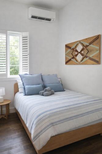 a bedroom with a large bed with blue pillows at Summer House Magnetic Island in Arcadia